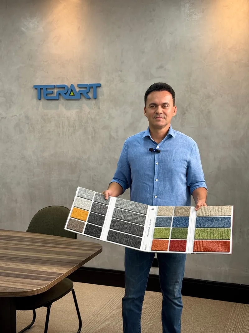 Especialista da Terart apresentando catálogo de carpetes Belgotex no showroom